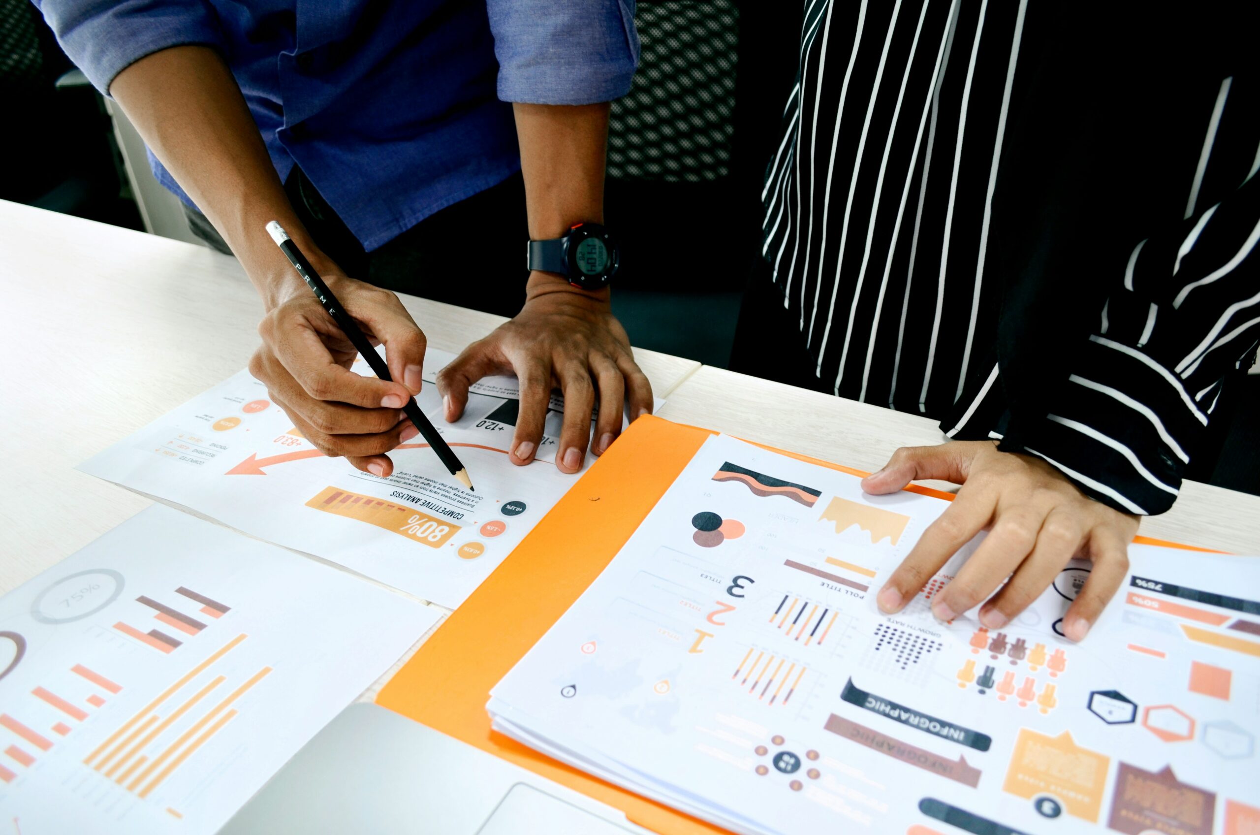 Team collaborating on SEO infographics and charts with graphs and data analysis documents.